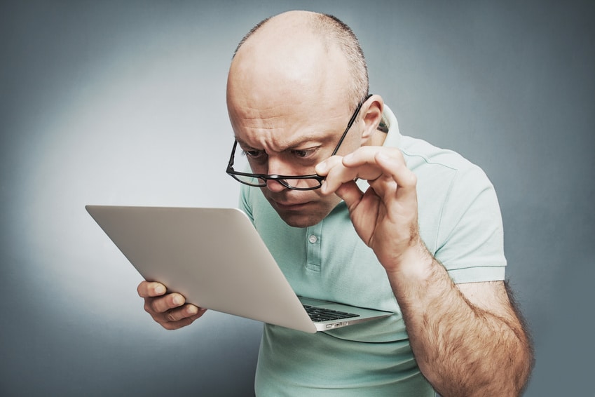 Closeup portrait surprised man working on laptop computer lookin