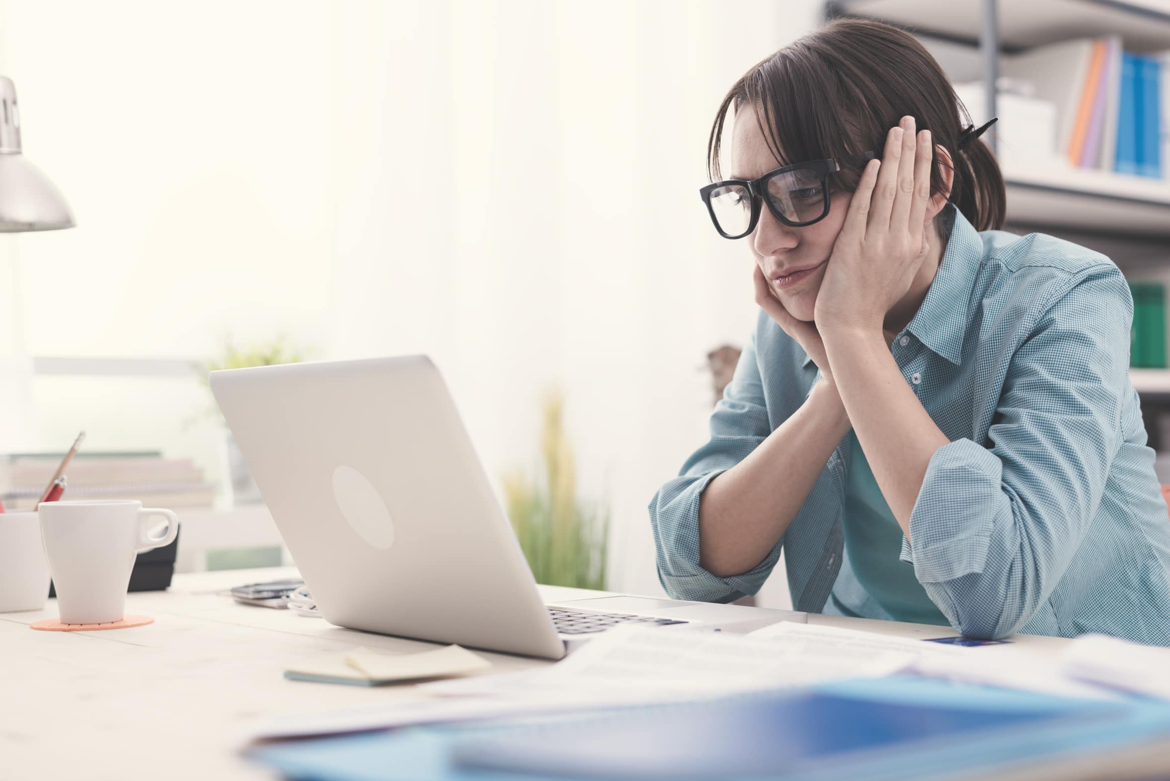 Bored woman working with her laptop